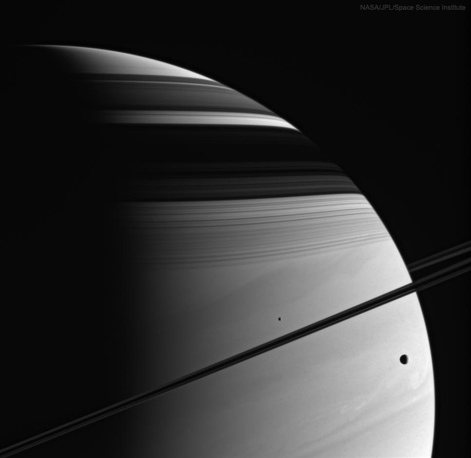 2 спутника расположились по разные стороны кольца Сатурна