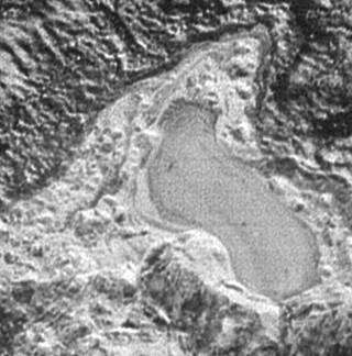 Изображения показывает маленькое замерзшее озеро на Плутоне