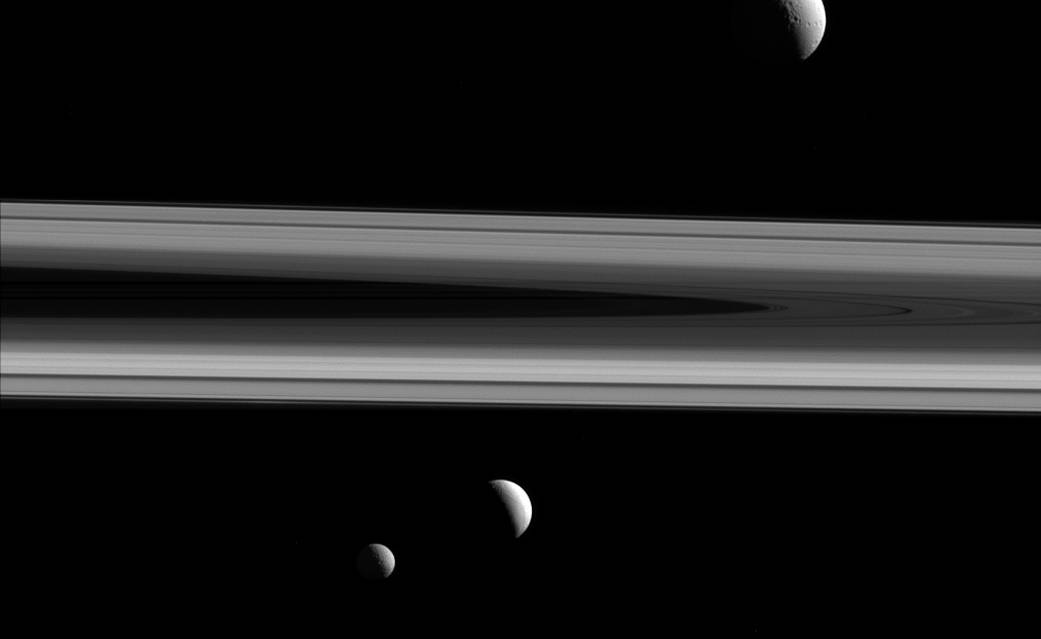 Фото трех спутников Сатурна на фоне колец